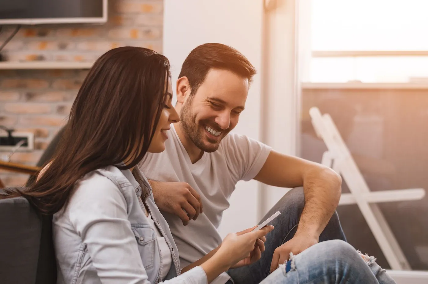 Couple qui consulte la plateforme CourtiersEstrie.ca sur un téléphone